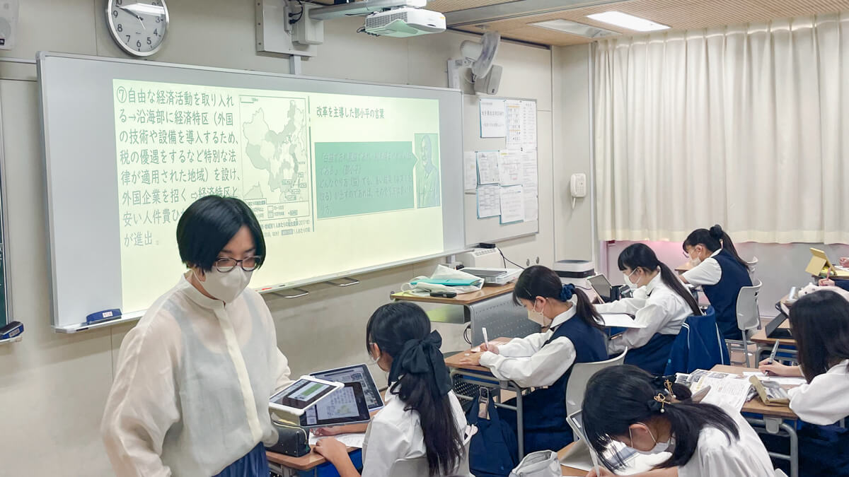 iPadを2台持ちながら机間指導する近藤先生